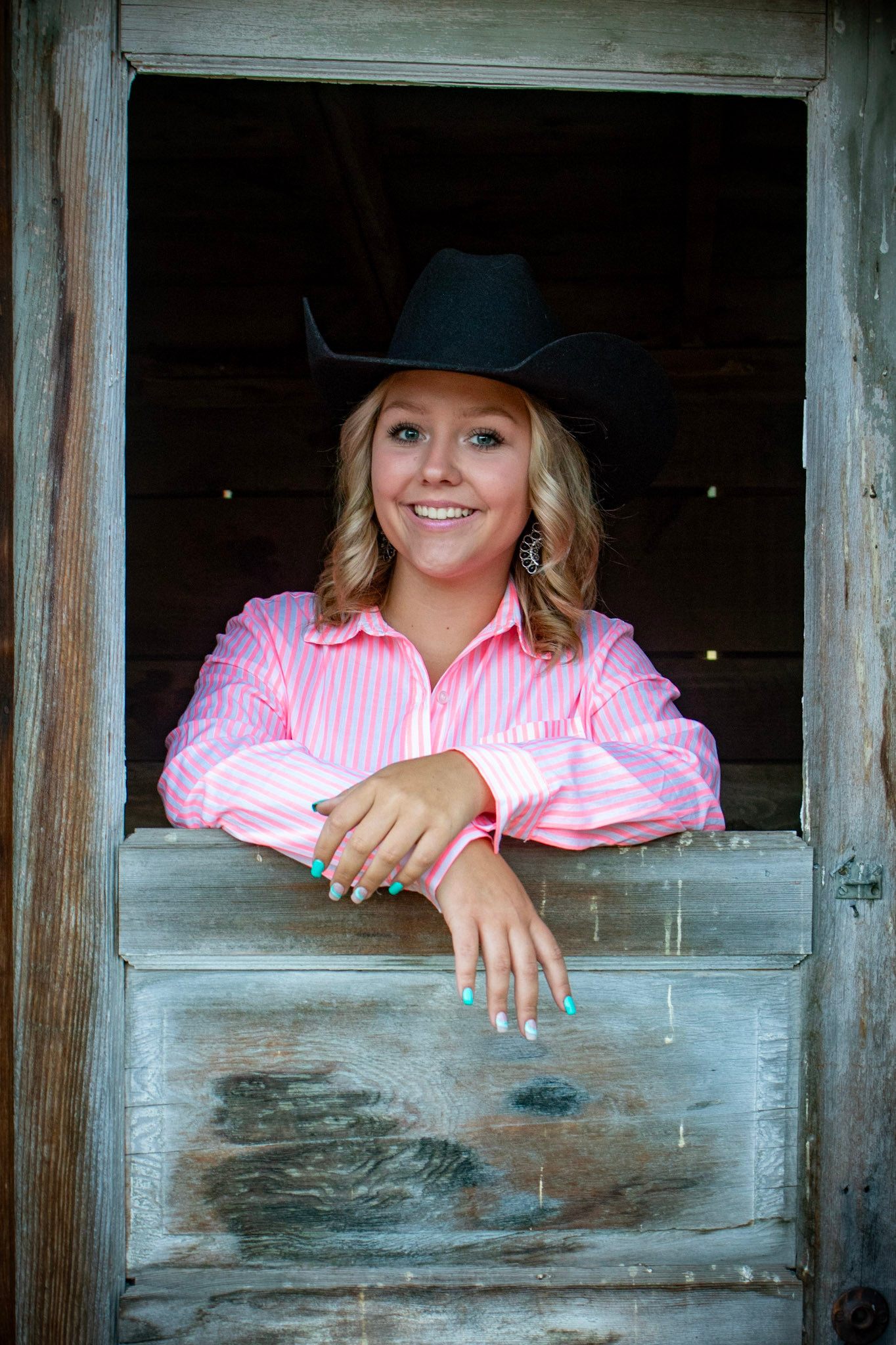 Cowgirl portrait in barn window